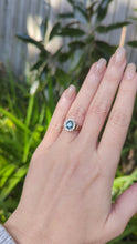 Load and play video in Gallery viewer, 1980s Halo ring with Teal sapphire and white spinel in 9ct yellow and white gold.
