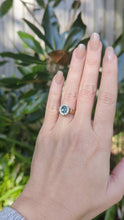 Load and play video in Gallery viewer, 1980s Halo ring with Teal sapphire and white spinel in 9ct yellow and white gold.
